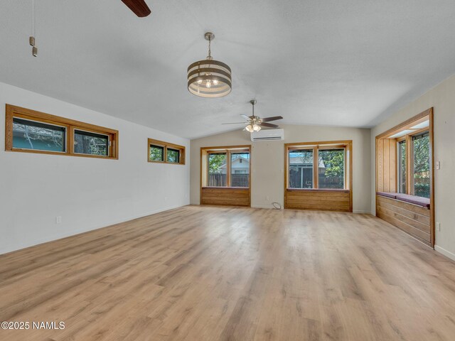 415 W Apache Rd, Flagstaff, AZ 86001 - unfurnished living room featuring a ceiling fan, light wood-type flooring, lofted ceiling, a wall mounted AC, and a chandelier