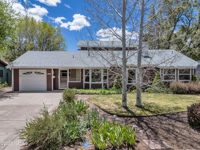415 W Apache Rd, Flagstaff, AZ 86001 - view of front facade with a garage, concrete driveway, a shingled roof, and a front lawn