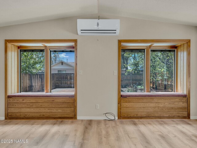 415 W Apache Rd, Flagstaff, AZ 86001 - unfurnished dining area with an AC wall unit, vaulted ceiling, wood finished floors, and baseboards
