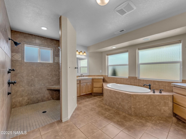 415 W Apache Rd, Flagstaff, AZ 86001 - full bathroom featuring vanity, a bath, tiled shower, tile patterned flooring, and a textured ceiling
