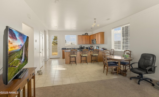 kitchen featuring a kitchen breakfast bar, an inviting chandelier, and light tile patterned floors