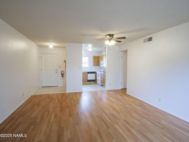 2401 N W St Unit 107, Flagstaff, AZ 86004 - unfurnished living room featuring light wood-style floors, ceiling fan, a textured ceiling, and baseboards