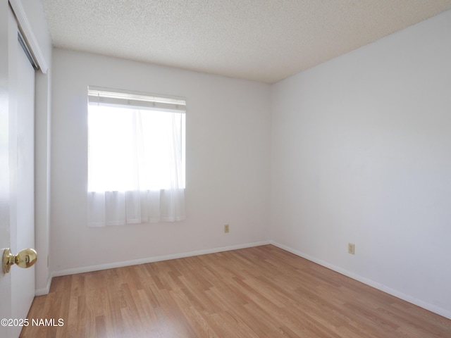 2401 N W St Unit 107, Flagstaff, AZ 86004 - empty room with light wood-style floors, a textured ceiling, and baseboards