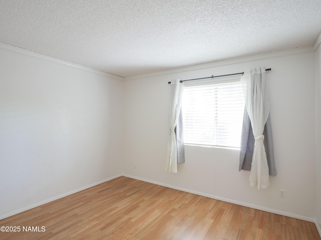 2401 N W St Unit 107, Flagstaff, AZ 86004 - empty room featuring wood finished floors, a textured ceiling, crown molding, and baseboards