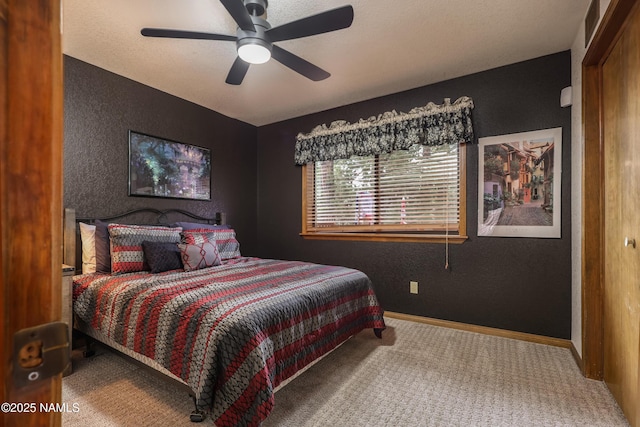 carpeted bedroom featuring a textured wall, baseboards, and a ceiling fan