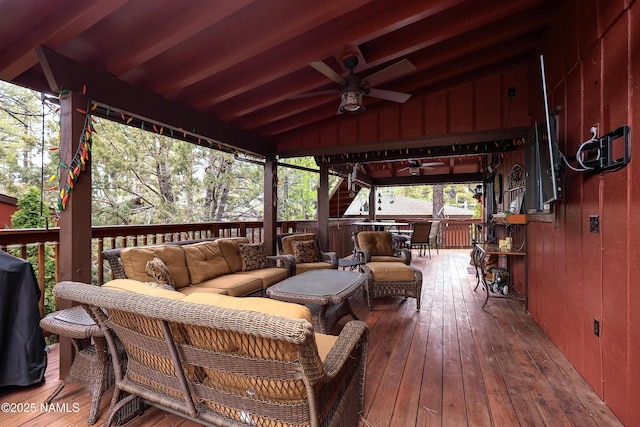 wooden terrace with an outdoor living space and ceiling fan