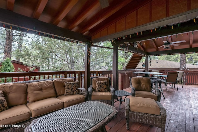 wooden terrace with outdoor lounge area, a ceiling fan, and outdoor dining space