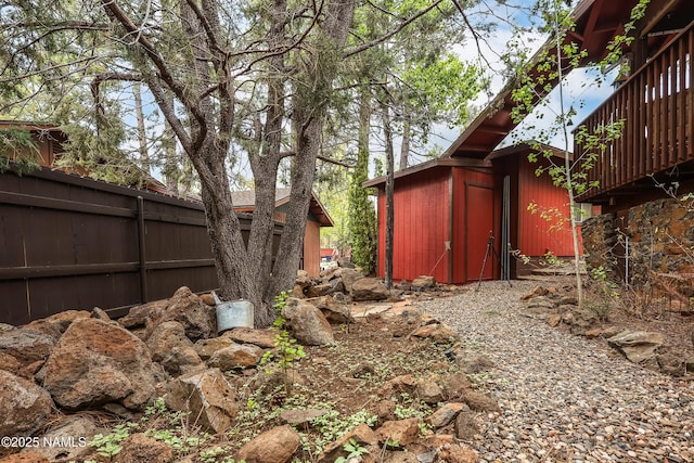 view of yard featuring fence and an outbuilding