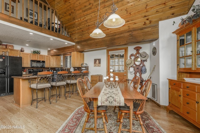 dining area with light wood-type flooring, recessed lighting, a high ceiling, and wooden ceiling