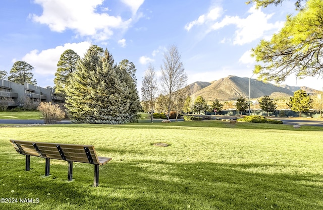 surrounding community with a mountain view and a lawn