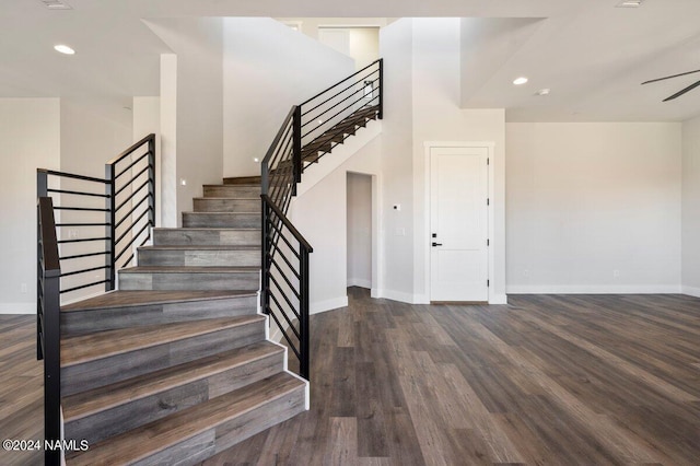 stairway with hardwood / wood-style flooring and ceiling fan