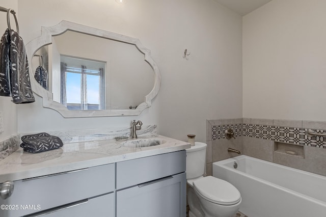 bathroom with vanity, a tub to relax in, and toilet