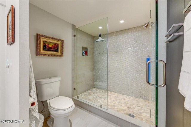 full bathroom featuring a stall shower and toilet