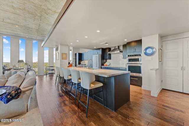 kitchen with light countertops, appliances with stainless steel finishes, a breakfast bar, and dark wood-style flooring