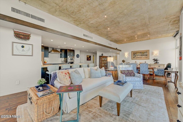 living room featuring baseboards, hardwood / wood-style floors, and visible vents