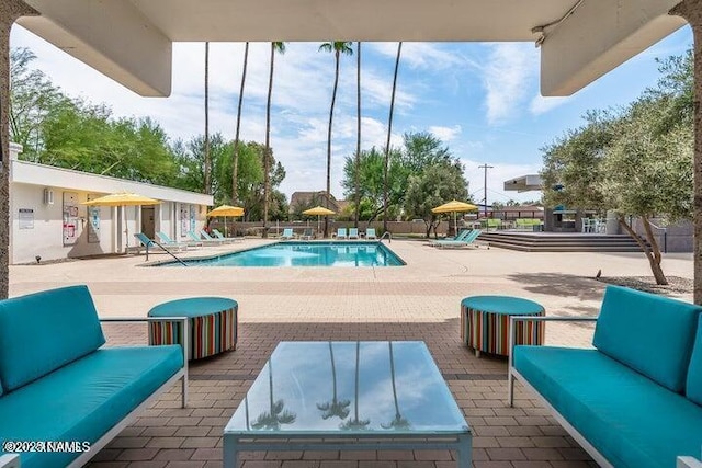 pool featuring a patio area, fence, and an outdoor hangout area