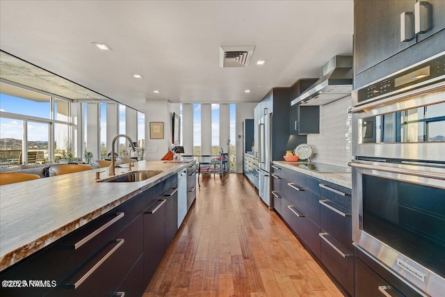 kitchen featuring expansive windows, a sink, modern cabinets, and stainless steel appliances