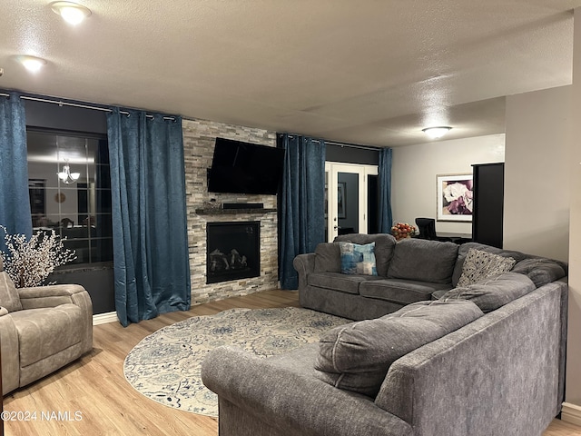 living room featuring hardwood / wood-style flooring, a textured ceiling, and a fireplace