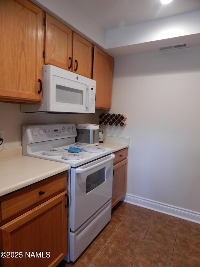 1000 N Beaver St Unit 116, Flagstaff, AZ 86001 - kitchen featuring white appliances, dark tile patterned floors, visible vents, and light countertops