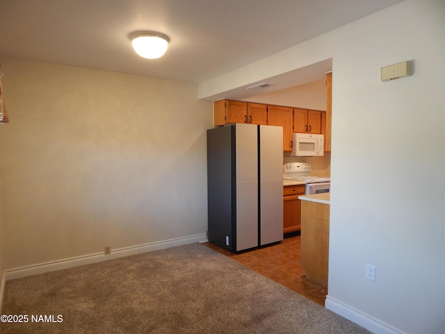 1000 N Beaver St Unit 116, Flagstaff, AZ 86001 - kitchen featuring white appliances, light countertops, carpet, and brown cabinets