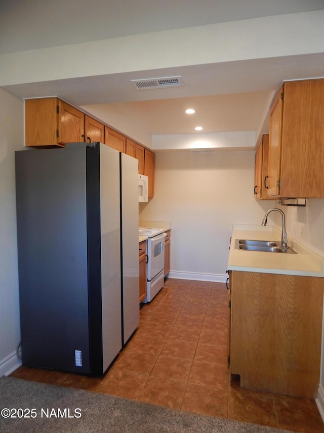1000 N Beaver St Unit 116, Flagstaff, AZ 86001 - kitchen featuring white appliances, light countertops, tile patterned flooring, recessed lighting, and brown cabinetry