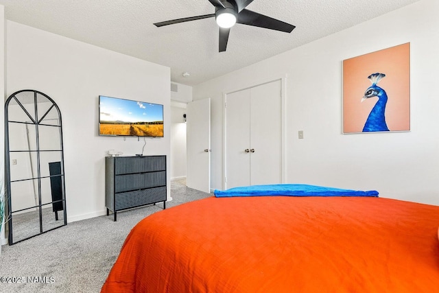 bedroom with ceiling fan, light colored carpet, and a textured ceiling