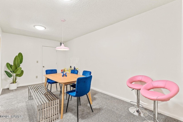 dining area with carpet floors and a textured ceiling