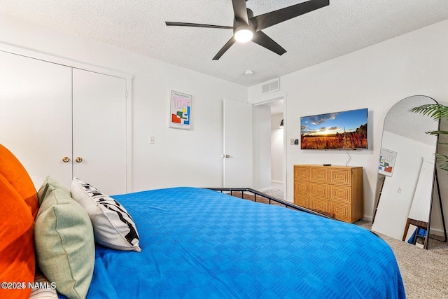 bedroom featuring ceiling fan, carpet, and a textured ceiling