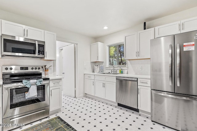 kitchen with stainless steel appliances, tasteful backsplash, and white cabinets