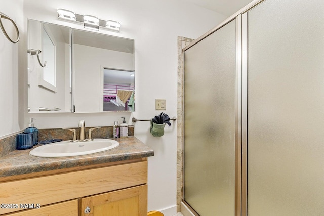 bathroom with vanity and a shower with shower door