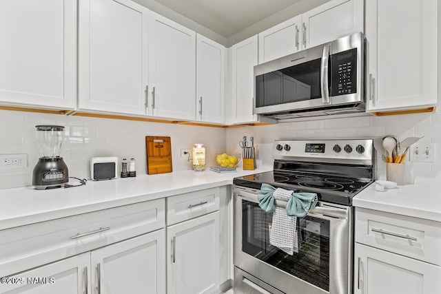 kitchen featuring tasteful backsplash, appliances with stainless steel finishes, and white cabinets