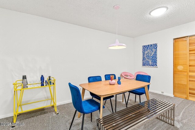 carpeted dining room with a textured ceiling