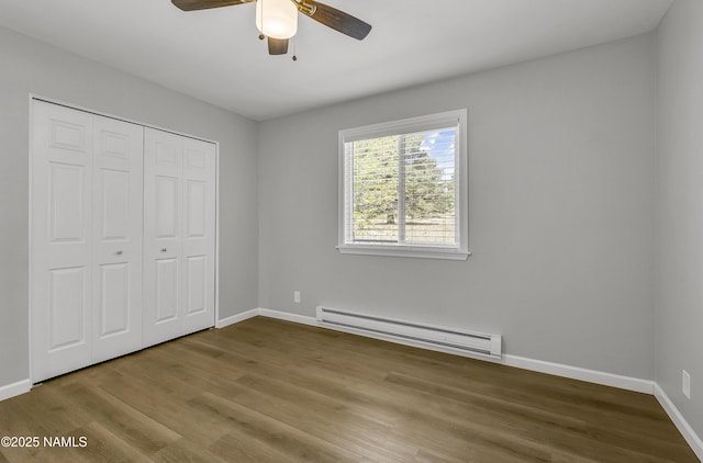 7815 Prairie Dog Ln, Flagstaff, AZ 86004 - unfurnished bedroom with baseboard heating, baseboards, and wood finished floors