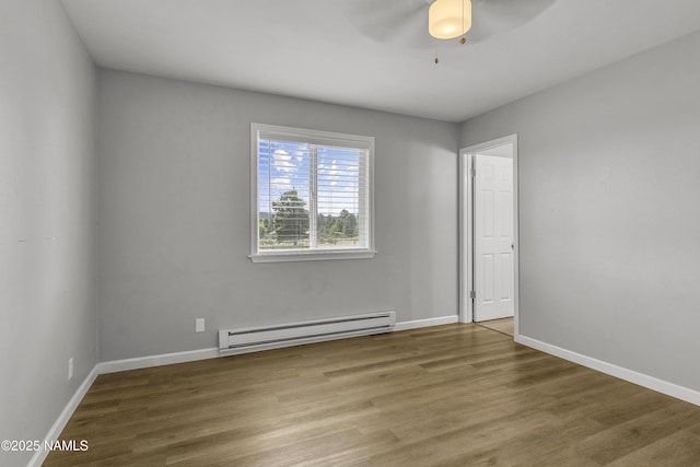 7815 Prairie Dog Ln, Flagstaff, AZ 86004 - unfurnished room featuring a baseboard heating unit, a ceiling fan, wood finished floors, and baseboards