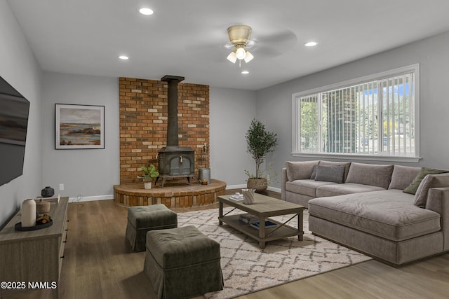 7815 Prairie Dog Ln, Flagstaff, AZ 86004 - living room featuring a ceiling fan, wood finished floors, a wood stove, baseboards, and recessed lighting