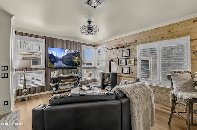 3001 E Butler Ave Unit 21, Flagstaff, AZ 86004 - living area featuring a wood stove, wood walls, wood finished floors, and ornamental molding