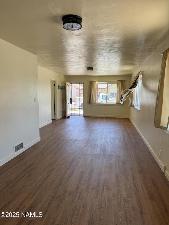 401 N Kinsley Ave, Winslow, AZ 86047 - unfurnished living room with dark wood finished floors and baseboards