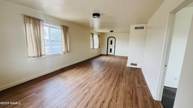 401 N Kinsley Ave, Winslow, AZ 86047 - unfurnished living room featuring wood finished floors, plenty of natural light, and baseboards