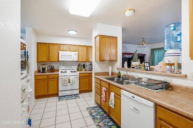 4551 E Allison Dr, Flagstaff, AZ 86004 - kitchen with sink, white appliances, light tile patterned floors, and kitchen peninsula