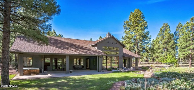 3605 N Langdale Trl, Flagstaff, AZ 86001 - rear view of property featuring a hot tub, a patio, a yard, a chimney, and roof with shingles