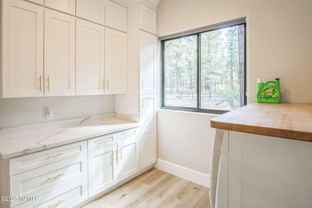 3605 N Langdale Trl, Flagstaff, AZ 86001 - kitchen with light wood-type flooring, white cabinetry, light stone counters, and baseboards
