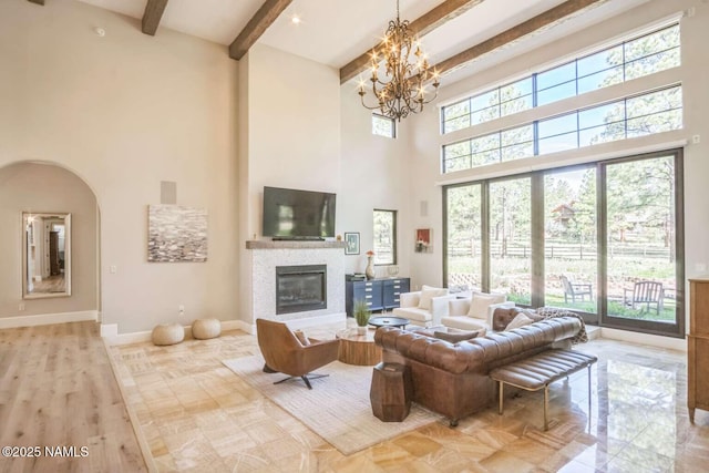 3605 N Langdale Trl, Flagstaff, AZ 86001 - living room featuring a high ceiling, beamed ceiling, a chandelier, a fireplace, and baseboards