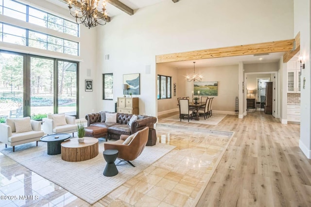 3605 N Langdale Trl, Flagstaff, AZ 86001 - living room with a chandelier, beam ceiling, baseboards, light wood-style floors, and a towering ceiling