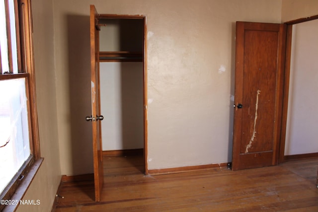 unfurnished bedroom with wood-type flooring and a closet