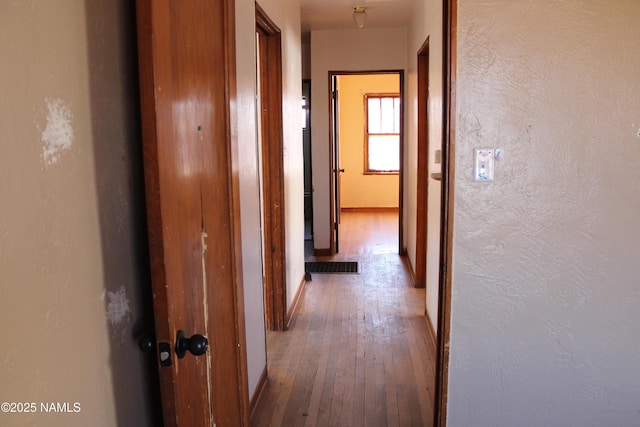 corridor with hardwood / wood-style floors