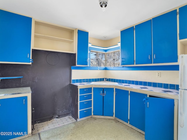 kitchen with blue cabinetry and white refrigerator