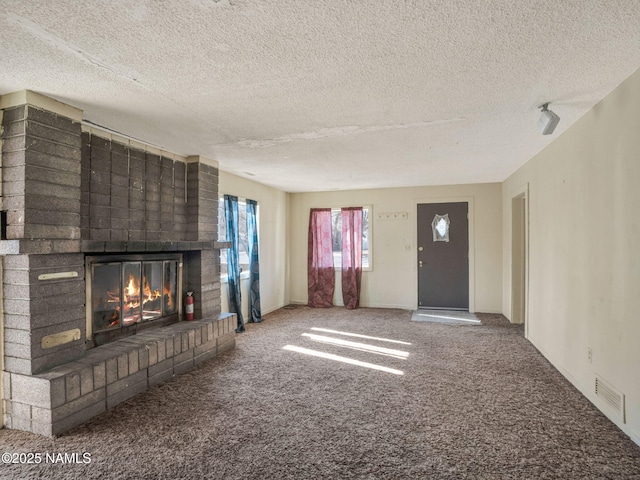 unfurnished living room featuring a fireplace, a textured ceiling, and carpet flooring