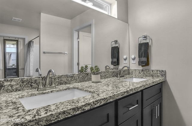 full bathroom featuring double vanity, visible vents, and a sink