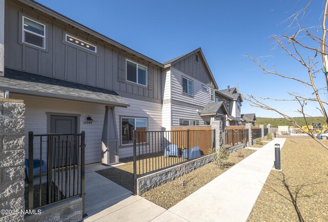 view of front of house with board and batten siding and fence private yard