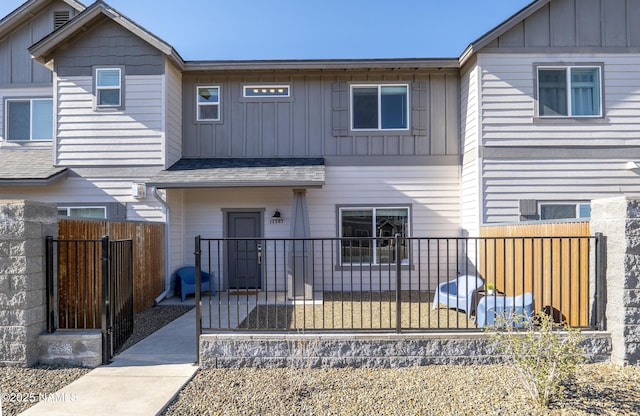 view of front of property with a gate, board and batten siding, and fence private yard